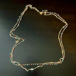 Gold dangling necklace with beaded accents